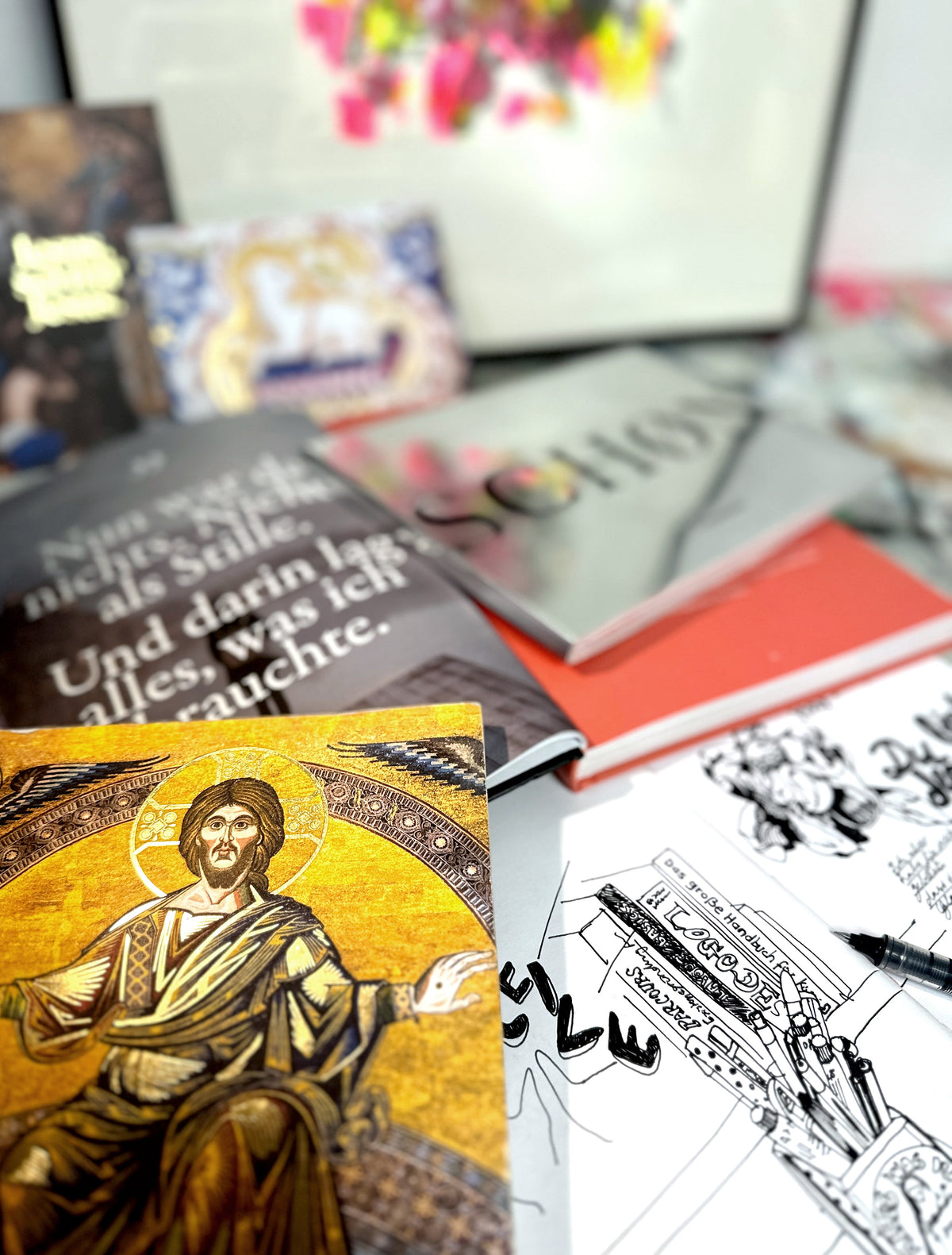 Schreibtisch mit Skizzenbüchern, Logo-Entwürfen und Inspirationskarten